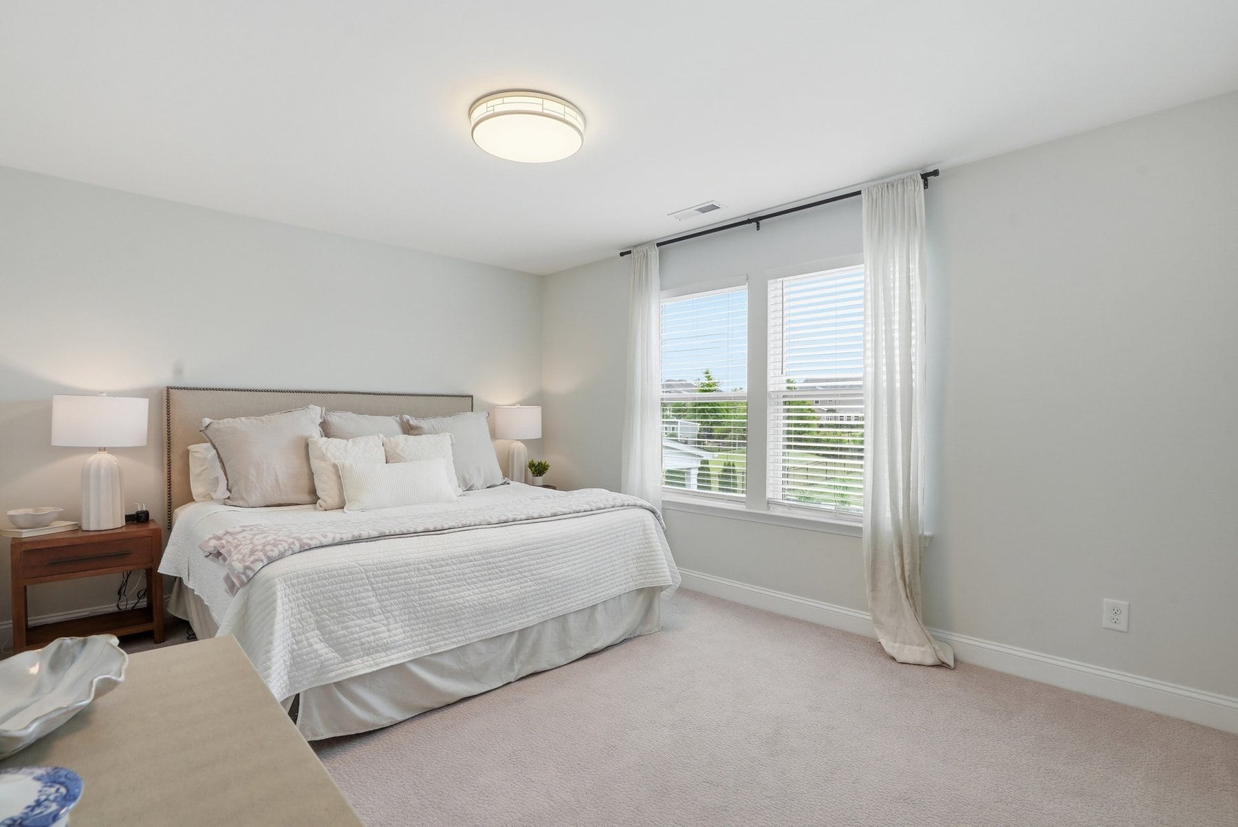 Primary bedroom with large windows and neutral finishes